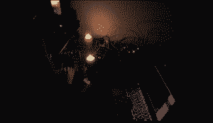 Indistinct. A dark room, candles, small lights.