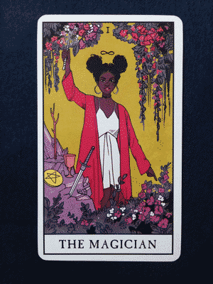 The Magician from the Modern Witch Tarot. She stands in a strong pose, with a rod in her hand and a n infinity symbol floating above her head. Plants grow above and below. Beside her are a wand, a cup, a sword, and a pentacle.